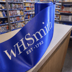 100mm Wide Royal Blue Ribbon Custom Printed for WH Smith with a white logo print for a grand opening by Personalised Printed Ribbons