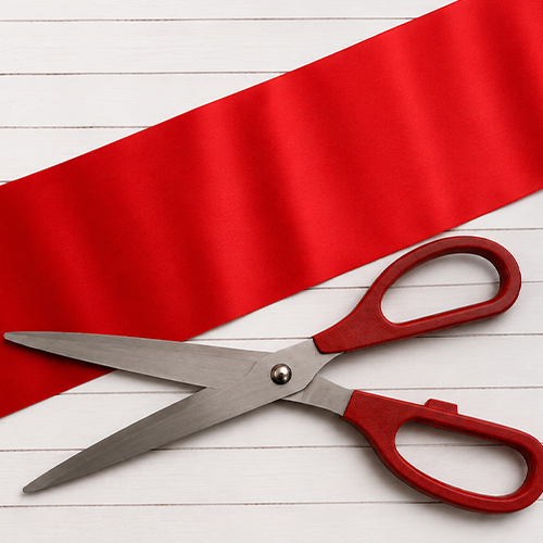 Extra wide red ribbon and giant scissors for ribbon cutting event
