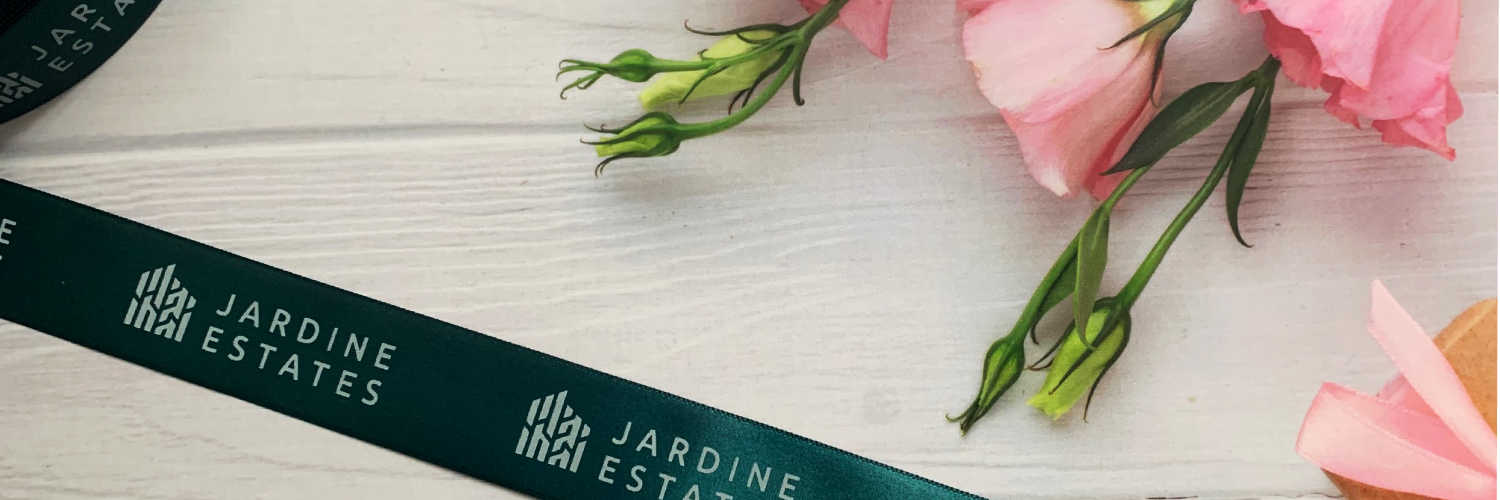 Dark Green Ribbon With A White Logo Repeat Printed by Personalised Printed Ribbons Next Day Dleivery on Custom Printed Ribbons