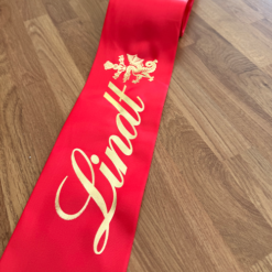 Wide Red Ribbon Printed with a metallic gold logo print for a chocolate company By Personalised Printed Ribbons