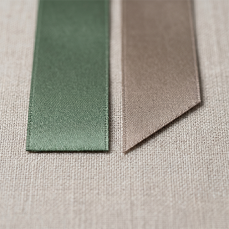 Comparison of straight cut vs 45 degree bevel cut satin ribbon edges showing precision thermal heat-sealing for wedding favours.
