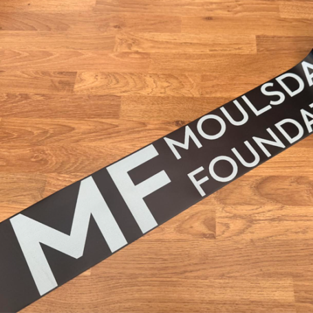Black satin ribbon with large solid white logo and block print